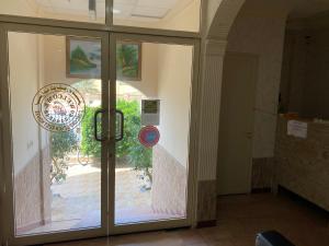 a glass door with a sign in front of it at Concord Beach House in Dibba