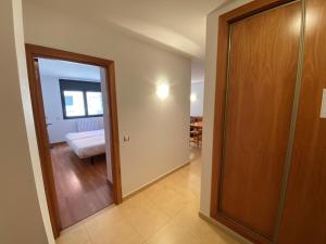 un couloir avec une porte menant à une chambre dans l'établissement Residencial Sol i Ski 23 4p Ransol El Tarter Zona Grandvalira, au Tarter