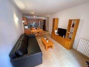 - un salon avec un canapé noir et une table dans l'établissement Residencial Sol i Ski 23 4p Ransol El Tarter Zona Grandvalira, au Tarter