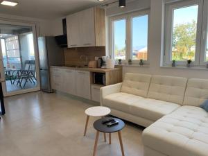a living room with a white couch and a table at APARTMANI SUNSIDE NIN in Nin