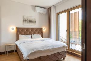 a bedroom with a bed and a large window at Belgrade Center Apartment Lux in Belgrade