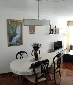 uma sala de jantar com uma mesa branca e cadeiras em Cruxa Apartments garaje incluido em Santiago de Compostela