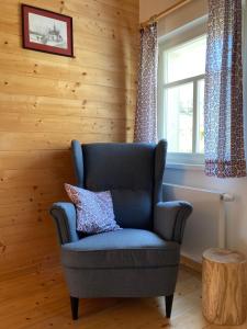 einem blauen Stuhl in einem Zimmer mit Fenster in der Unterkunft Chalupa Rozmarýna in Mařenice