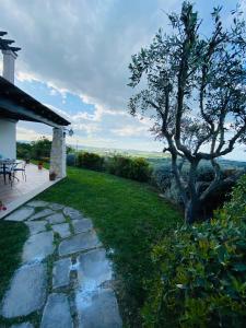 a garden with a tree and a stone walkway at CASA VACANZA FELICITA' in Porto Potenza Picena