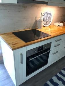 a kitchen with a counter with a stove top oven at Koselig maritim leilighet sentralt i Stavern in Stavern