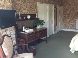 Pokój z biurkiem, telewizorem i drzwiami w obiekcie Whashton Springs Farmhouse B&B w mieście Richmond