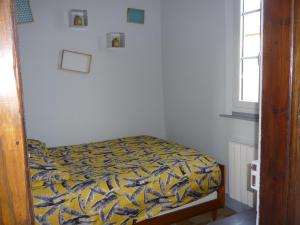 a bedroom with a bed with a yellow and blue blanket at L'ESCALE in Camps-en-Amiénois