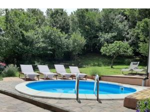 a swimming pool with lounge chairs and a swimming pool at house Paola in Tribalj