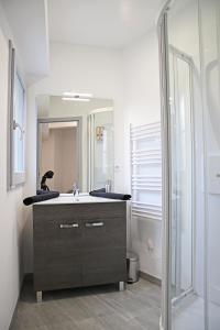 ein Bad mit einem Waschbecken und einem Spiegel in der Unterkunft #Cosy Moments By Eauz'Homes - WiFi-Netflix in Eauze