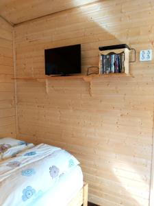 Habitación con cama y TV en la pared. en Bakkakot 3 Cozy Cabin In The Woods en Akureyri