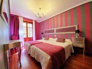 a bedroom with a large bed and a chandelier at La Casa de Lorenzo in Laguardia