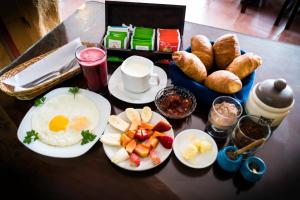a breakfast table with eggs and fruit and croissants at Hosteria Llanovientos in Baños