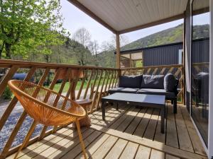 eine Terrasse mit einem Sofa und einer Bank auf einer Terrasse in der Unterkunft Chalet Gringlee in Goebelsmuhle
