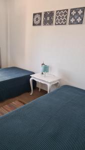 ヴィラ・ノヴァ・デ・ミルフォンテスにあるSummer Comfortのベッド2台、テーブル、椅子が備わる客室です。