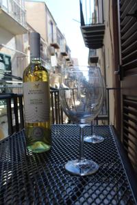 a bottle of wine and two wine glasses on a table at Maresole Cefalù in Cefalù