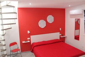 1 dormitorio rojo con 1 cama y pared roja en Maresole Cefalù, en Cefalú