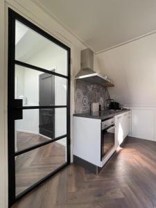 une cuisine avec une grande porte en verre menant à une pièce dans l'établissement Dierenweide Upstairs, à Goedereede