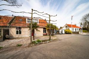 une rue vide dans une ville avec des maisons et des arbres dans l'établissement Dierenweide Upstairs, à Goedereede