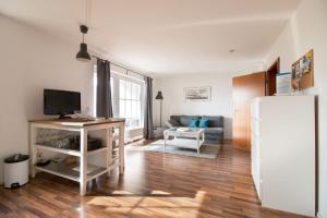 ein Wohnzimmer mit einem Sofa und einem Kühlschrank in der Unterkunft fewo1846 Strandresidenz Wassersleben - Luv - komfortables Studio-Apartment mit Balkon und Meerblick in Harrislee