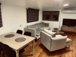 a living room with a couch and a table and chairs at אירוח חם בלב in Qiryat Shemona