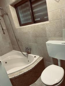 a bathroom with a tub and a toilet and a sink at אירוח חם בלב in Qiryat Shemona