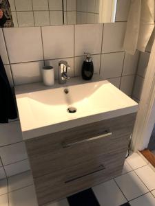a bathroom with a white sink and a mirror at Koselig maritim leilighet sentralt i Stavern in Stavern