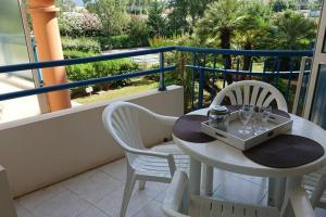 stół i 2 krzesła na balkonie z widokiem w obiekcie T2 climatisé à 5 minutes à pied de la plage avec parking, piscine et wifi w Fréjus