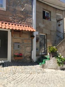 un edificio de piedra con porche y puerta en Casa da Fonte Grande, en Belmonte