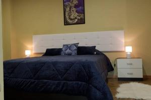 - une chambre avec un grand lit et une table de chevet blanche dans l'établissement Casa Madureira - Paraíso centenário do Douro, à Sabrosa