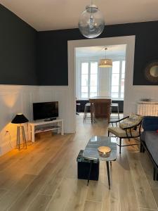 a living room with a couch and a table at SON DES MOUETTES PLAGE in Trouville-sur-Mer