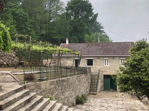 a stone building with a green door and stairs at QUINTA do SOUTO BARCIADEMERA in Barciademera