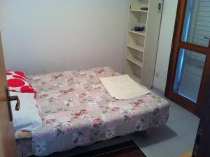 a small bedroom with a bed with a pink blanket at Apartments Frog Creek in Slano