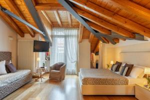 um quarto com uma cama, um sofá e uma televisão em Hotel Rovere em Treviso
