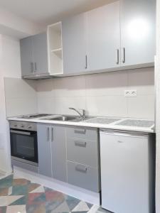 eine Küche mit weißen Schränken und einem Waschbecken in der Unterkunft Apartman-Stan na dan -Stolac in Stolac