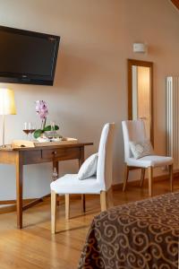 a room with a desk and two white chairs at Hotel Rovere in Treviso