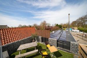 un patio avec un banc et un parking avec des panneaux solaires dans l'établissement Dierenweide Upstairs, à Goedereede