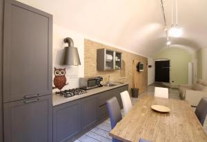 una cucina e una sala da pranzo con tavolo e cucina di Luxury Suite apartment Angiolieri a Siena