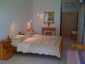 a bedroom with a large bed and a mirror at Scarpantos in Amoopi
