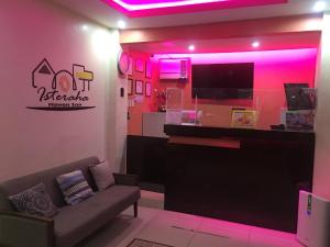 Isteraha Haven Inn في زامبوانغا: غرفة معيشة مع أريكة وأضواء وردية