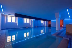 una grande piscina in un edificio con illuminazione blu di Residenza Santa Cecilia a San Vincenzo