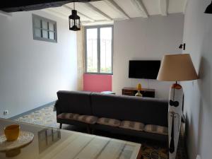 a living room with a couch and a table at LE LOGIS DE LA PIERRE in Périgné