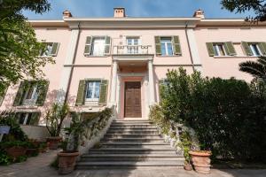 una casa rosa con escaleras delante en Residenza Santa Cecilia, en San Vincenzo