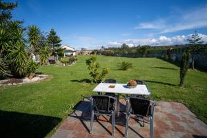 einen Tisch und Stühle auf einer Terrasse im Garten in der Unterkunft El Pinar in Ribadeo