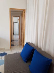 sala de estar con sofá y almohadas azules en La casa dei cugini, en Santa Marina Salina
