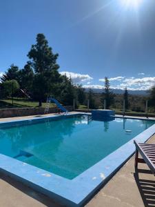 a large swimming pool with blue water at Cabaña julian in La Cumbrecita