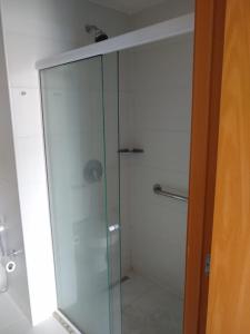 een douche met een glazen deur in de badkamer bij Flat Constelações in Campos dos Goytacazes