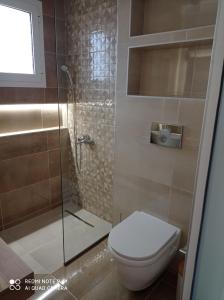 ein Badezimmer mit Toilette und Glasdusche in der Unterkunft Ankypy Studios in Kími