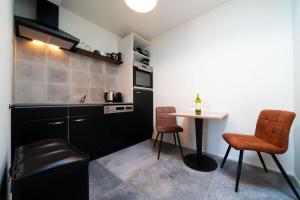 a kitchen with a small table and two chairs at De Dierenweiden in Goedereede