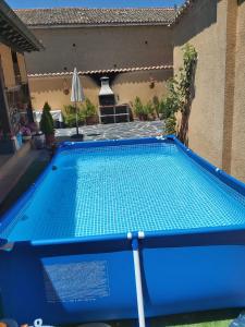 a blue swimming pool in front of a house at CASA RURAL LA FINCA DEL POZO a 1 hora de Madrid in Segovia