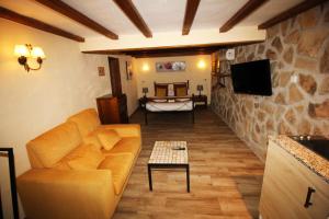 a living room with a couch and a tv at Finca El Destino in El Berrueco